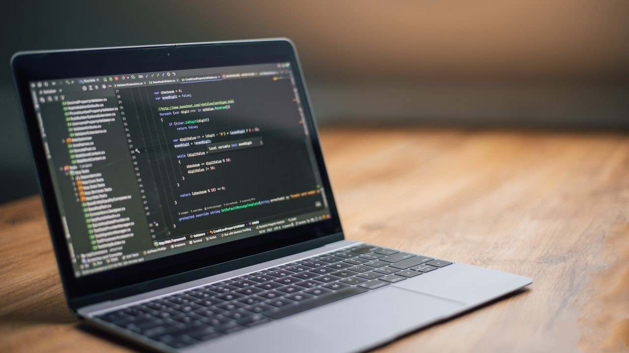 Laptop displaying source code for static and browser-rendered web scraping